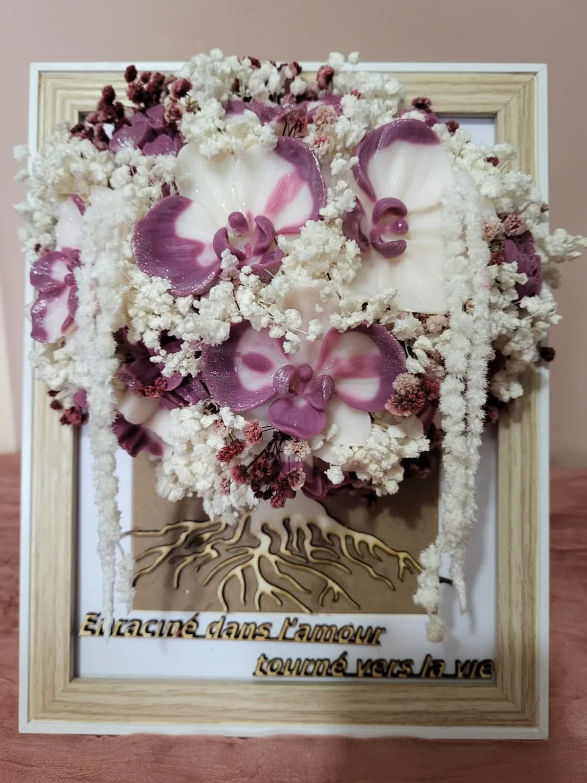 Cadre « Enraciné dans l’amour, tourné vers la vie » : orchidées prune et ivoire au-dessus d’un arbre de vie en bois