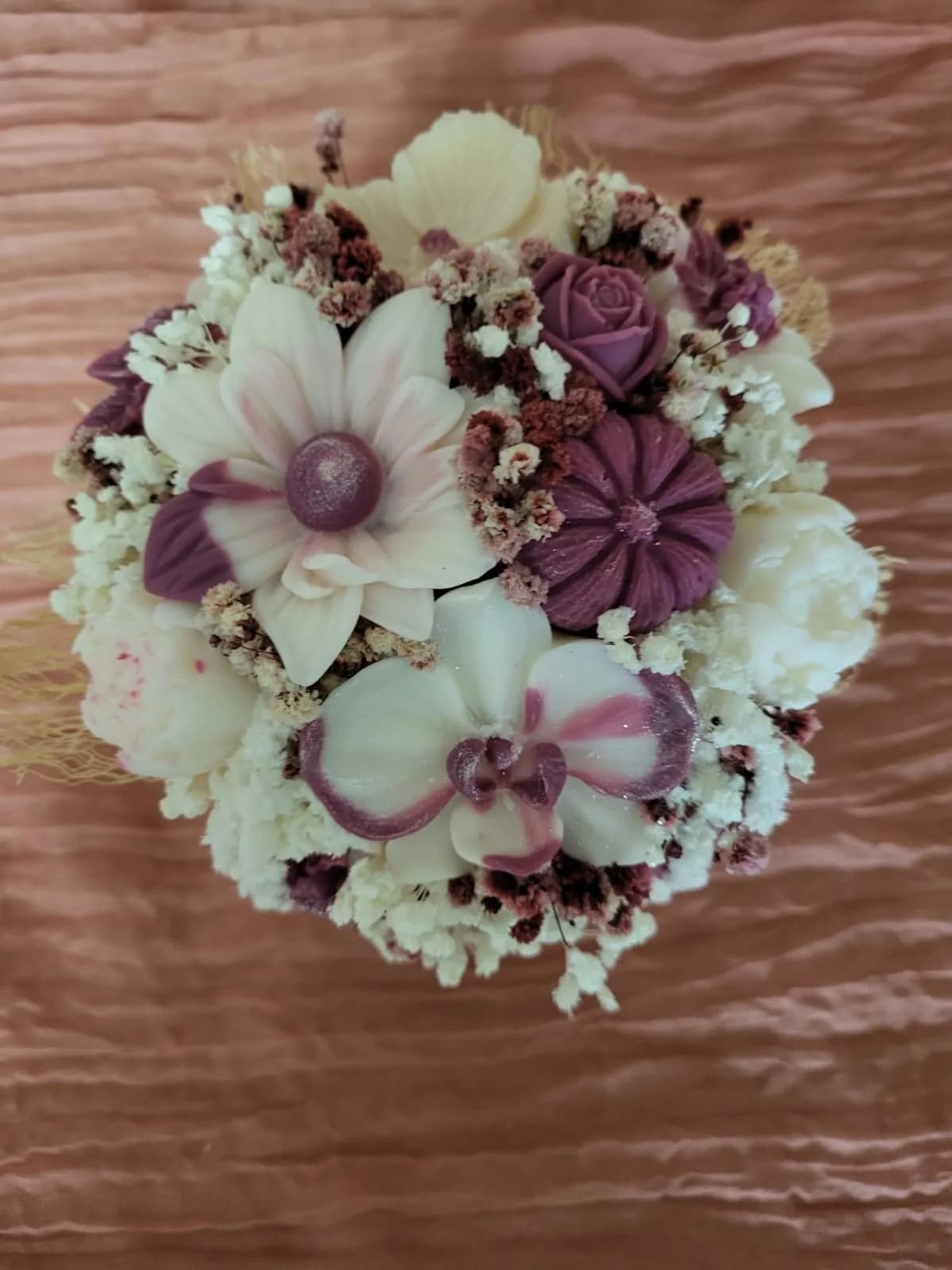 Bouquet prune et ivoire vu du dessus : orchidées, roses et fleurs de cire