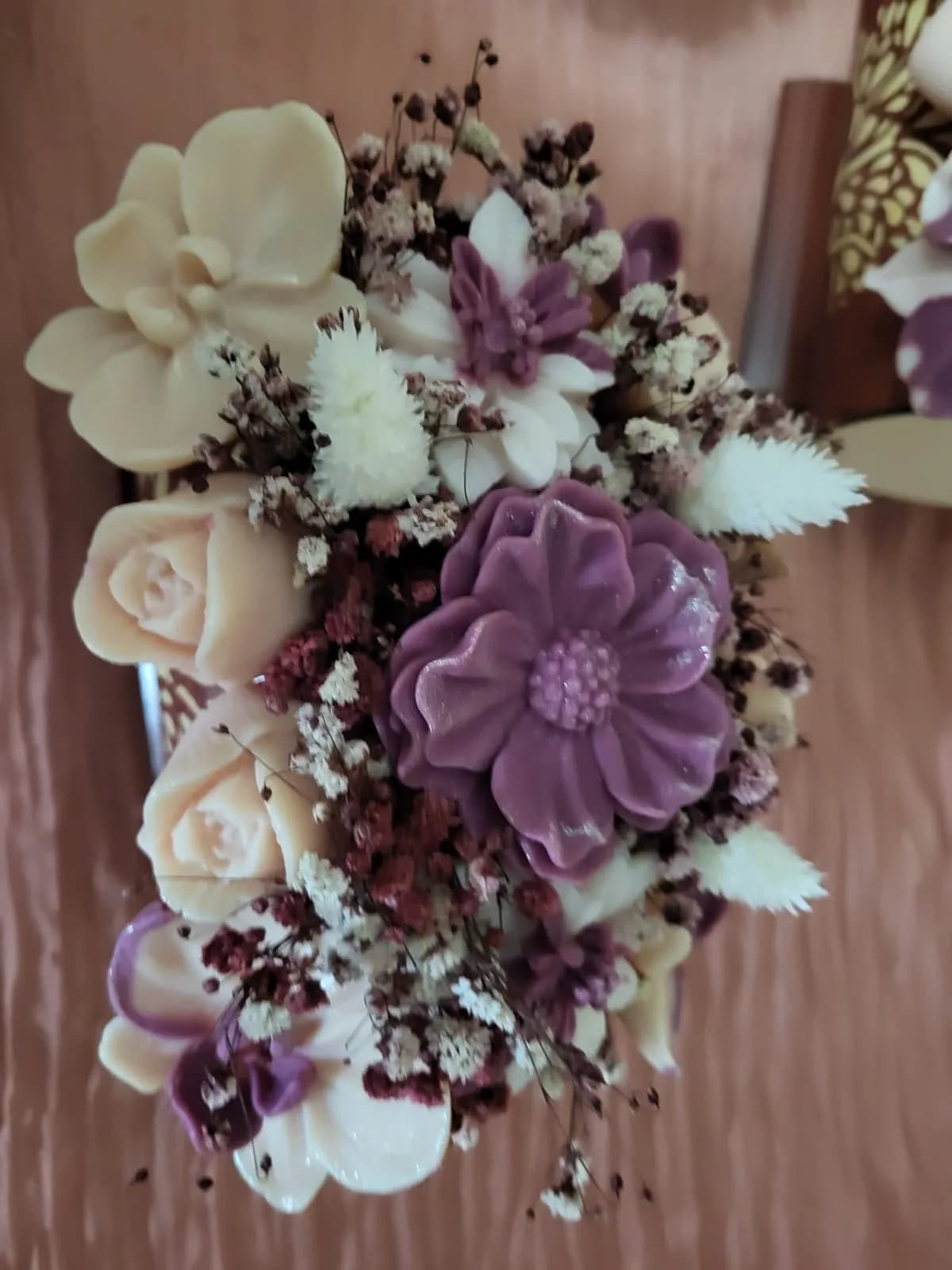 Détail d’un bouquet prune et ivoire : grande fleur prune, roses pêche et orchidées