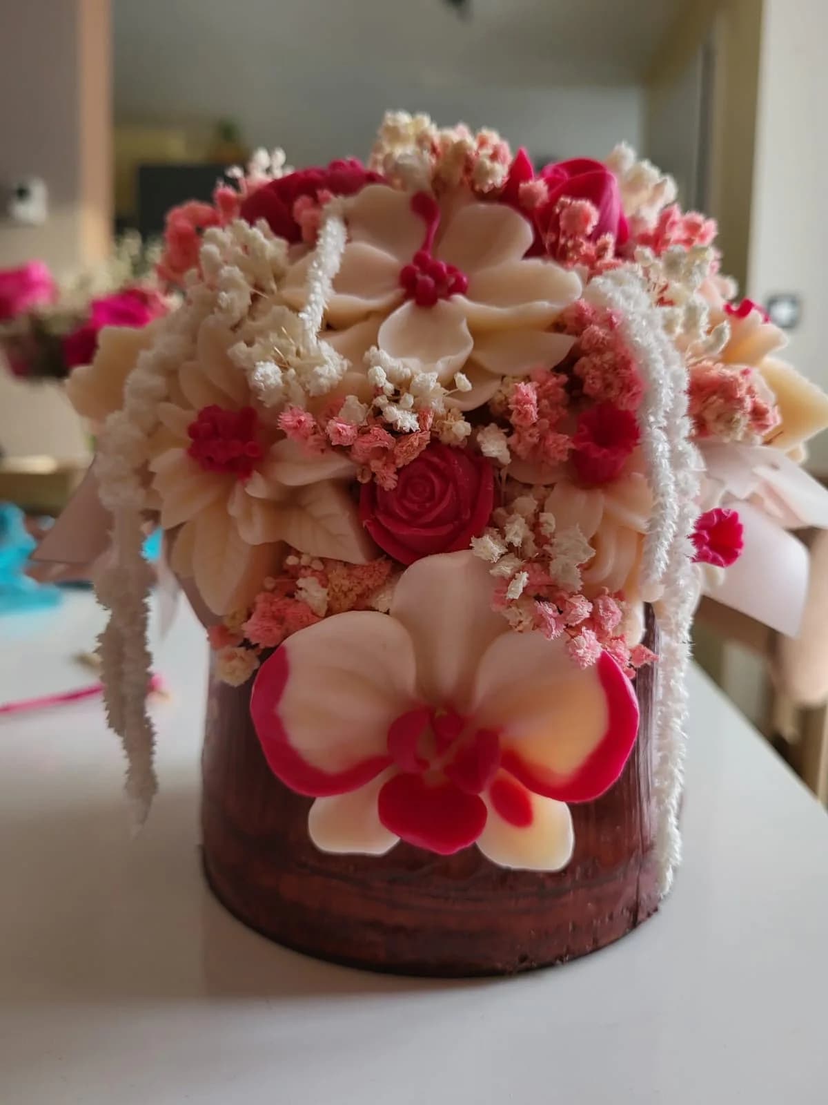 Bouquet Cascade : orchidées, roses et fleurs de cire rose et ivoire, d’où retombe de l’amarante blanche