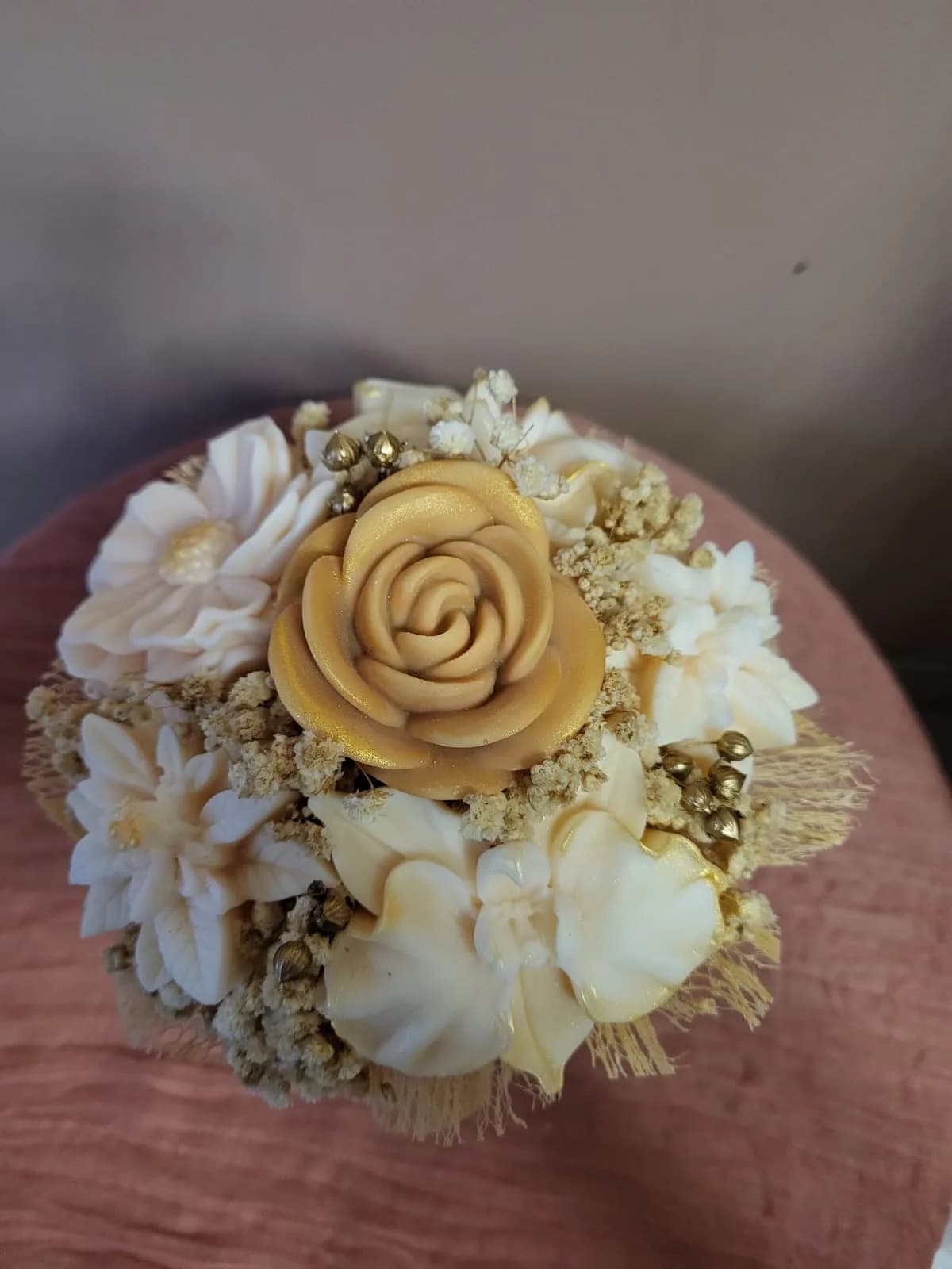Bambou L vu du dessus : une rose dorée entourée de fleurs de cire ivoire et de perles dorées