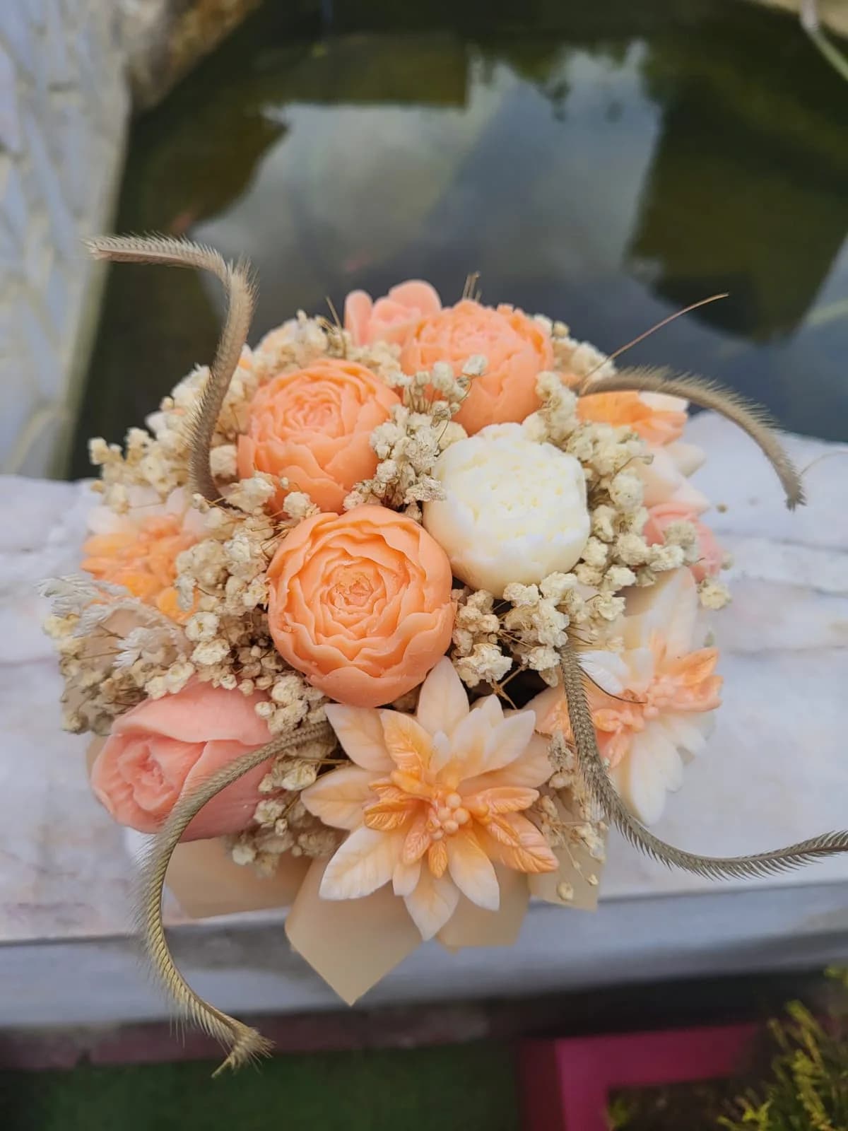 Bambou XL vu de près : roses, pivoines et dahlias de cire pêche et ivoire, herbes séchées dorées