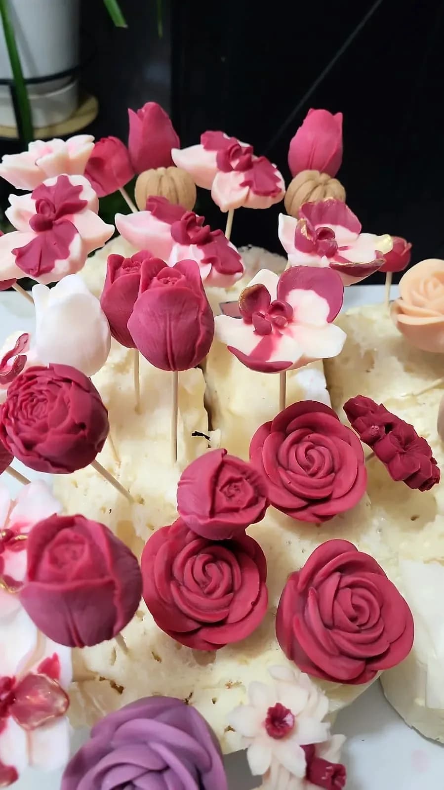 Fleurs de cire avant l’assemblage : roses framboise, tulipes et fleurs bicolores sur leurs tiges